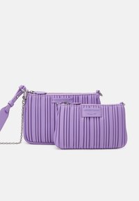 Dwie fioletowe torby plisowane wykonane z miękkiego materiału. Jedna jest większa z łańcuszkowym paskiem; obie mają naszywkę z logo z przodu.