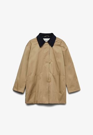 Šviesiai rudos spalvos lengvas paltas su tamsiai mėlynu apykakle, dviem priekinėmis kišenėmis ir sagomis per vidurį. Pasižymi laisvu siluetu ir švelnia tekstūra.