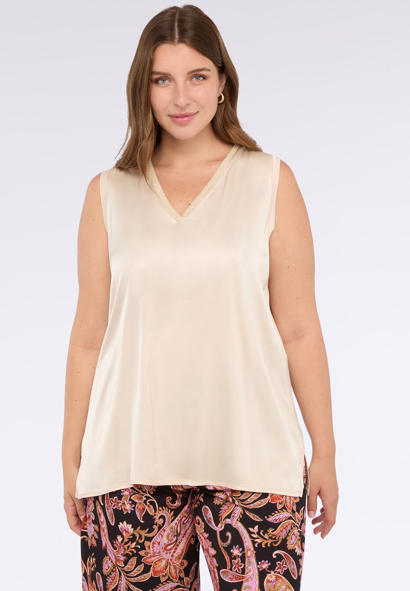 Top senza maniche color crema con design a V, realizzato in tessuto morbido. Presenta un sottile bordo dorato attorno al collo.
