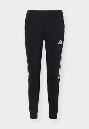 Czarne sportowe spodnie Adidas z białymi paskami po bokach i logo, elastyczną talią oraz zwężanymi nogawkami ze ściągaczami.