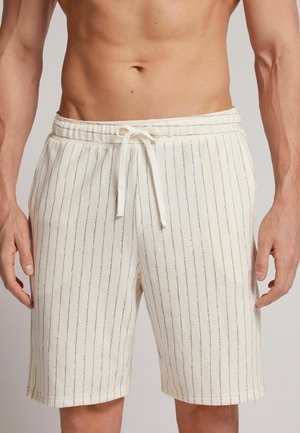 Cream-colored shorts with a textured fabric, featuring narrow vertical stripes and an elastic waistband with a drawstring. Suitable for casual wear.
