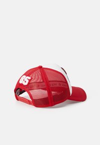 Red and white cap with mesh back, featuring a curved bill and embroidered "85" on the rear. Textured fabric with snapback closure.