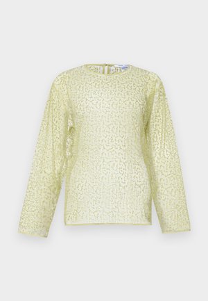 Blouse à manches longues de couleur jaune clair avec une finition texturée et pailletée. Présente un col rond et une fermeture éclair dissimulée au dos. Tissu lisse.