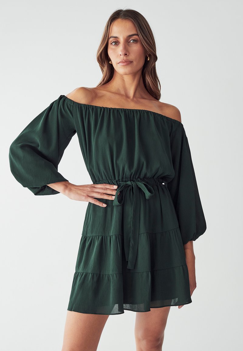 Grünes schulterfreies Kleid aus leichtem Material. Es hat Puffärmel, eine taillierte Taille mit einem Bindeband und einen gestuften Saum.