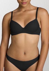 Reggiseno imbottito nero con spalline regolabili, tessuto liscio e design senza cuciture. Abbinato a un bikini brief nero coordinato.