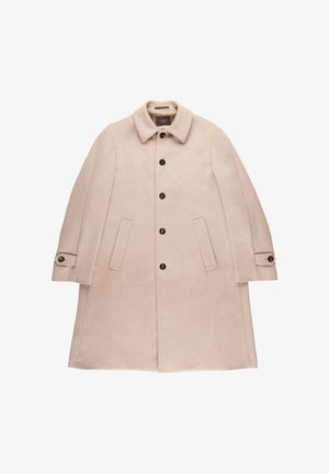 Beige wollen lange jas met kraag, vijf donkere knopen aan de voorkant, twee voorzakken en knoopbanden op de mouwen.