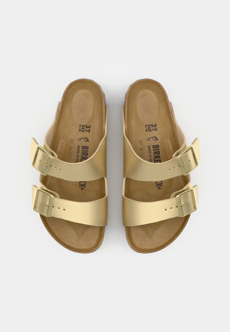 Goldene Sandalen mit zwei Riemen und verstellbaren Schnallen, aus glattem Leder gefertigt, mit einer konturierten braunen Fußbett, das Größen- und Markendetails anzeigt.