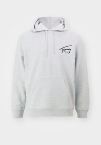 Šedá bawełněná mikina s kapucí a přední kapsou, stažitelnou kapucí a černým logem "Tommy Jeans" v horním levém rohu. Měkká textura, ležérní design.