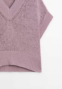 Vaaleanlila neulepaita, jossa on V-pääntie, lyhyet hihat ja ribbireunus. Avoin neulos tuo hengittävyyttä.