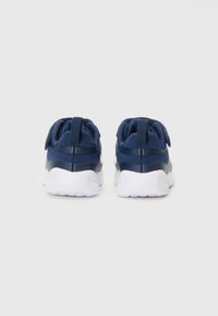 Marineblaue Sportschuhe mit einer strukturierten Oberseite, weißer Sohle und zwei hinteren Schlaufen für ein einfaches Anziehen. Verfügt über ein gepolstertes Design für mehr Komfort.