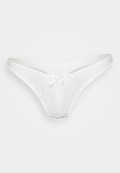 String blanc en dentelle fleurie, avec un fin bandeau élastique et un petit nœud central. Texture lisse, design à couverture minimale.