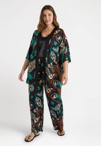 Kehämainen musta kimono, jossa on turkoosi, ruskea ja kreemi paisley-kuvio, yhdistettynä samankaltaisiin kuvioituihin housuihin. Sujuva kangas, rento istuvuus.