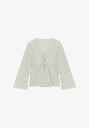 Knit blouse in cream with a V-neck, long bell sleeves, scalloped hem, and a front tie closure. Features intricate lace patterns throughout.