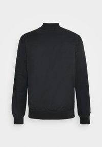 Giacca bomber nera realizzata in tessuto liscio, con polsini e colletto a coste, dal design semplice e senza hardware o motivi visibili.