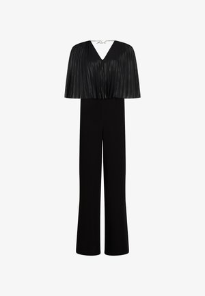 Fekete overál, pleated köpeny stílusú felső résszel, V-alakú kivágással és széles lábú nadrággal. Simább anyagból készült, amely elegáns sziluettet kínál.