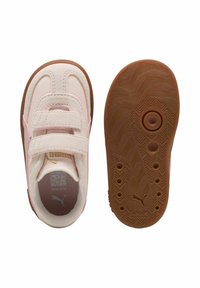 Zapatillas rosas claras con correas de velcro, tejido texturizado y suela de goma marrón con un patrón ondulado. Incluye detalle del logo en el interior.