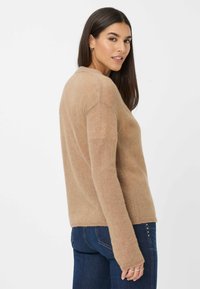 Maglione a maglia marrone chiaro con scollatura rotonda e maniche lunghe. Presenta un tessuto morbido e Texture e una vestibilità rilassata in vita.
