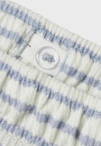 Vit och ljusblå randig tyg med en samlad struktur och en klar knapp med en tygögla för fäste.