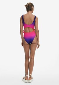 Maillot de bain une pièce avec un design dégradé du rose au violet, doté d'une ouverture dans le dos et de détails à nouer. Texture lisse, coupe sportive.