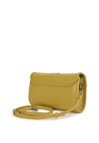 Sac bandoulière en cuir jaune avec fermeture à rabat et sangle réglable enroulée à côté, sur fond blanc.