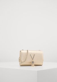 Borsa a tracolla in metallo dorato con finitura testurizzata, tracolla a catena e un evidente dettaglio hardware a forma di V. Forma rettangolare con chiusura a pattina.