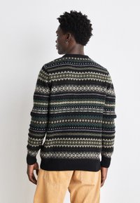 Schwarzer Strickpullover mit mehrfarbigen geometrischen Mustern in Grün, Creme und Blau. Rippbündchen und Saum sowie ein runder Halsausschnitt.