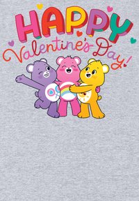 Diseño gráfico que presenta tres osos de dibujos animados en púrpura, rosa y amarillo, con el texto "¡Feliz Día de San Valentín!" en colores brillantes sobre un fondo gris.