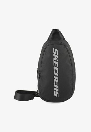 Mochila bandolera negra hecha de tela duradera. Cuenta con un gran bolsillo frontal con cremallera y un logotipo lateral en plata reflectante. Incluye una correa ajustable.