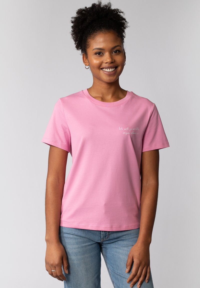 Korte mouwen, ronde hals, roze t-shirt met een kleine witte tekstgrafiek op de voorkant. Katoenen materiaal met een gladde textuur.