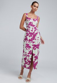 Robe à imprimé floral en vert clair avec des accents violet profond, dotée d'un col carré, d'une fermeture à boutons et d'une fente à l'avant.