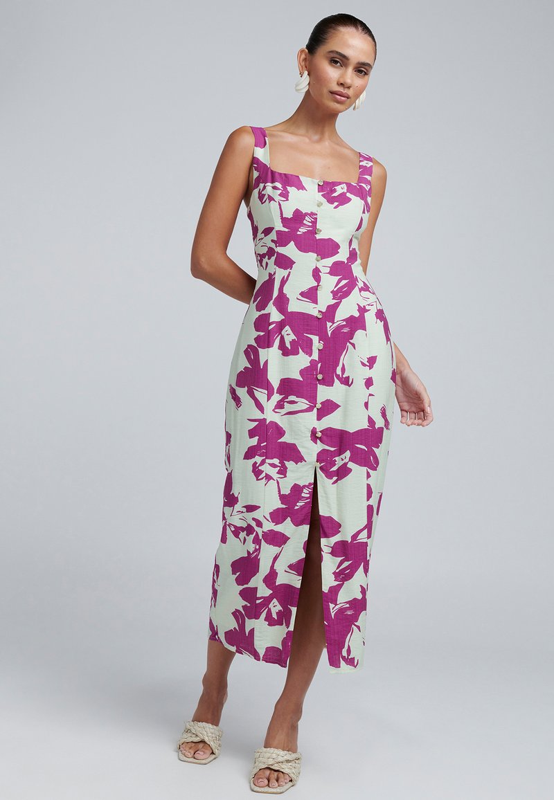 Robe à imprimé floral en vert clair avec des accents violet profond, dotée d'un col carré, d'une fermeture à boutons et d'une fente à l'avant.