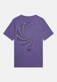 Lilla bomull t-skjorte med et sirkulært grafisk design i svart og hvit tekst, som leser "MESSI," med en logo i bunnen av midten.