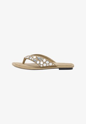 Tan suede flip-flop med en glat sål og en bred rem med sølv cirkulære udskæringer. Flad design med en minimal sort accent på sålen.