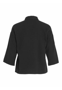 Črna, krajša jakna z teksturirano tkanino, ki ima razširjen ovratnik, široke rokave in stranske razpoke za dodaten detajl.