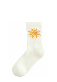 Weiße gerippte Socken mit einer aufgestickten gelben Sonne und rosa Strahlen. Das Design umfasst ein lächelndes Gesicht in der Mitte.