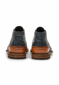 Botines de cuero negro texturizado con acentos azules, tacón marrón y nombre de la marca grabado. Suela resistente para un mejor agarre.