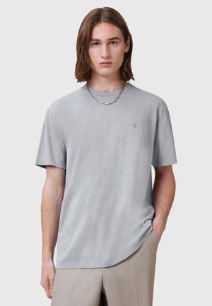 Grå kortærmet t-shirt lavet af blødt stof med en subtil tekstur, med en rund hals og et lille logo på brystet.