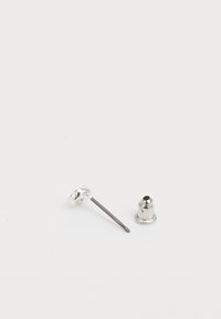 Silberne Metall-Ohrstecker mit einem runden, strukturierten Design und einem dünnen Stift. Enthält eine glockenförmige Rückseite für sicheren Halt.