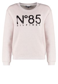 Sweat-shirt à manches longues beige clair avec texte noir "N°85 HILFIGER" et sequins sur la poitrine, poignets côtelés et encolure ronde.