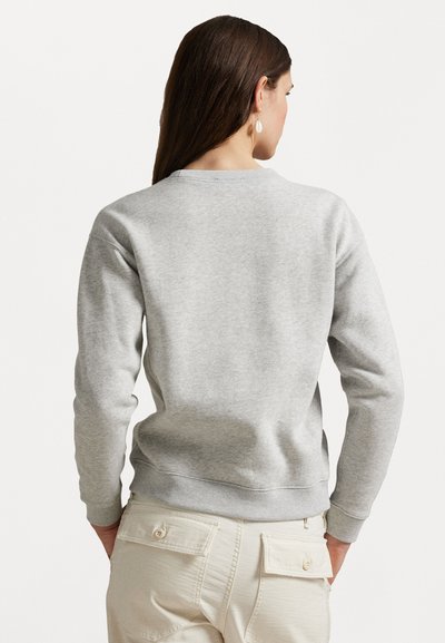 Grauer Sweatshirt mit Rundhalsausschnitt und gerippten Bündchen. Bietet eine weiche Textur und eine lockere Passform, kombiniert mit beigen Hosen.