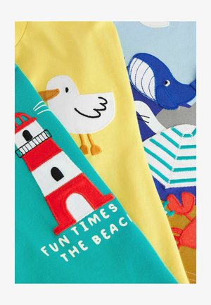 Drei bunte T-Shirts mit bestickten Motiven: ein Leuchtturm, eine Möwe und Strandelemente, in leuchtenden Farben und verspielten Mustern.