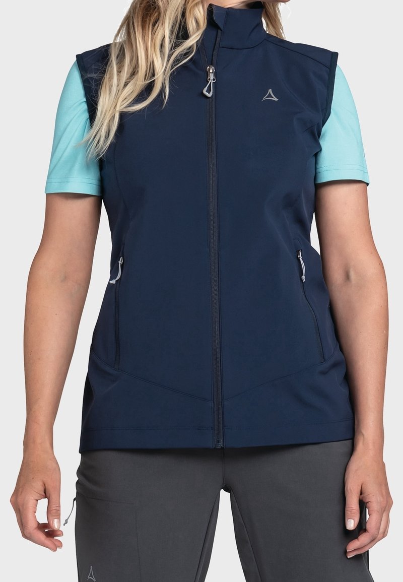 Námořnická modrá bezrukávová vesta s vysokým límcem, předním zipem a dvěma bočními kapsami. Vyznačuje se hladkou texturou a minimalistickým designem.