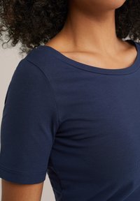T-shirt blu navy a maniche corte realizzato in cotone a coste, con un ampio scollo rotondo e una texture liscia.