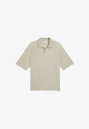 Polo de manga corta de color beige con cuello, dos botones y logo blanco de Puma en el pecho izquierdo.