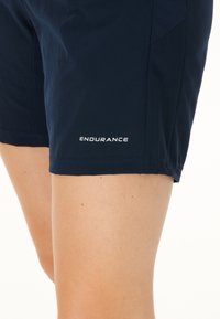 Marina shorts för träning i fuktavledande material, med en lätt design, slät textur och en vit "ENDURANCE"-logotyp.