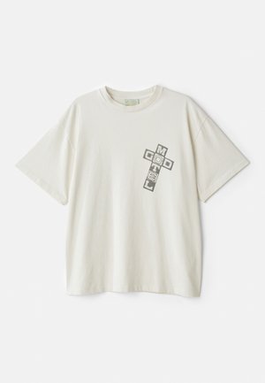 Cream-colored cotton t-shirt with short sleeves; features a graphic print saying "MOTEL" and "GOD" in a cross arrangement on the left chest.