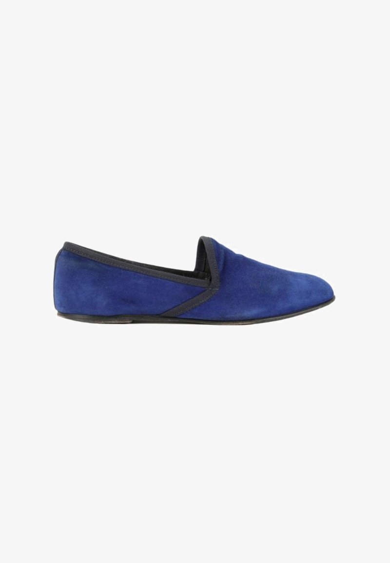 Chausson plat en daim bleu avec bordure noire et petit talon, vu de côté sur fond blanc.