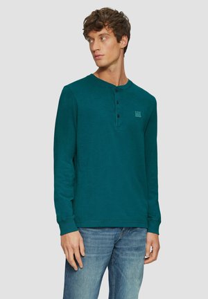 Langarm-Henley-Shirt in Teal mit rundem Ausschnitt, drei Knöpfen und kleinem Logo auf der Brust. Weicher Stoff, lässige Passform.