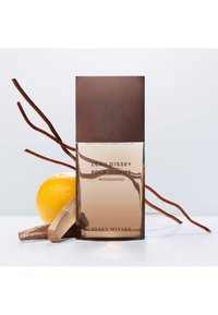 Bottiglia di profumo con base in vetro rettangolare, tappo in legno marrone, con un'etichetta riportante la scritta "L'Eau d'Issey Pour Homme Wood&Wood". Include accenti di limone e legno.