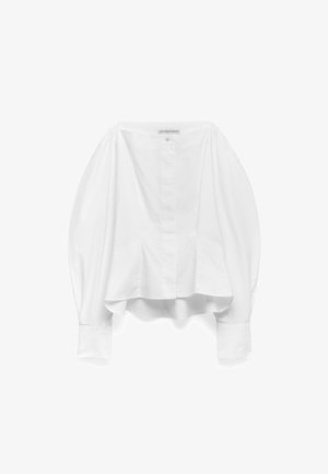 Chemise blanche, manches longues, forme ballon hautement arrondie, fermeture à boutons sur le devant, tissu en coton lisse, poignets texturés. L'ourlet arrière est arrondi.